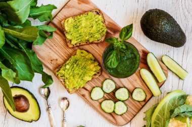 Üstten Görünüm. Yeşil smoothie ve avokado ile iki sandviç. sağlıklı vegan gıda