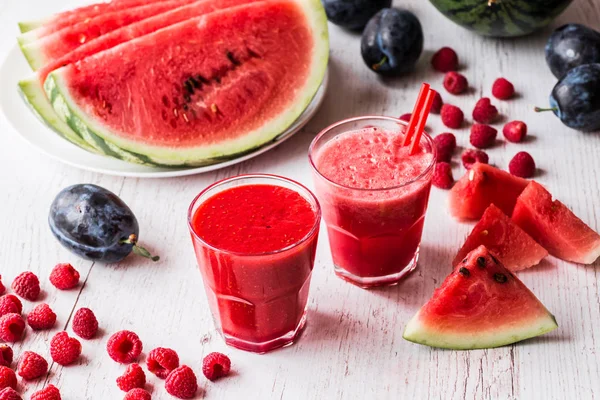 sağlıklı içecekler. Beyaz ahşap zemin üzerinde karpuz ve ahududu smoothies
