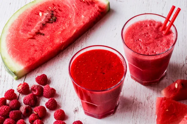 sağlıklı içecekler. Beyaz ahşap zemin üzerinde karpuz ve ahududu smoothies