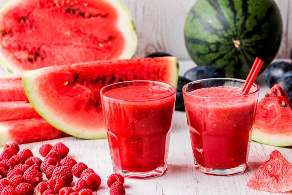 sağlıklı içecekler. Beyaz ahşap zemin üzerinde karpuz ve ahududu smoothies