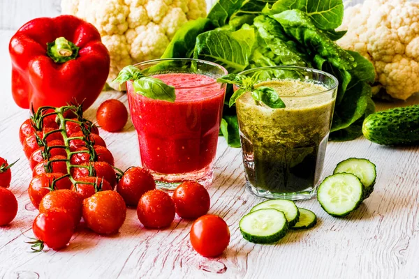 Frischer Tomatensaft und grüner Detox-Smoothie in zwei Gläsern auf weißem Holzgrund — Stockfoto