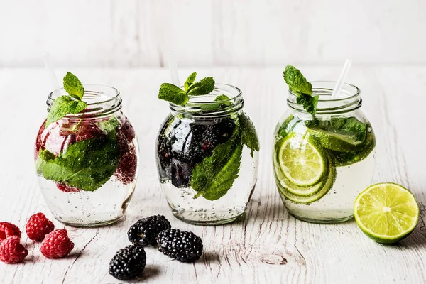 Üç çeşit Detoks su ile böğürtlen, çilek, Beyaz ahşap zemin üzerine kireç