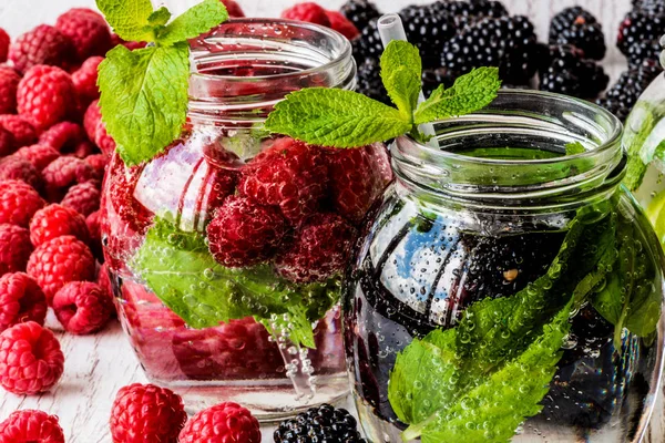 Dos tipos de agua de desintoxicación con mora y fresa sobre fondo de madera blanca — Foto de Stock