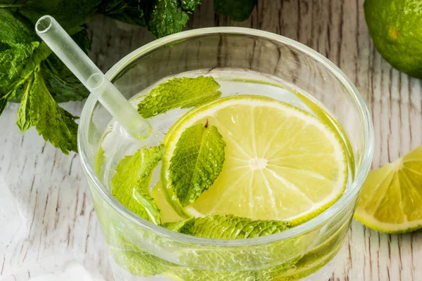 Mojito cocktail med lime, mynta och is på vit trä bakgrund. — Stockfoto