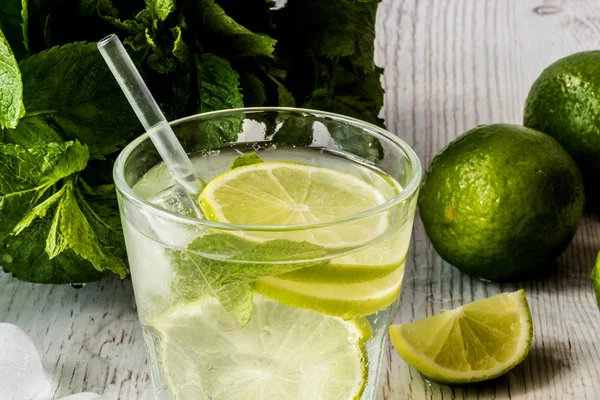 Mojito kokteyl limon, nane ve buz Beyaz ahşap zemin üzerinde.