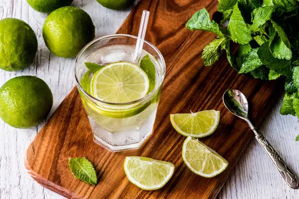 Mojito cocktail med lime, mynta och is på vit trä bakgrund. — Stockfoto