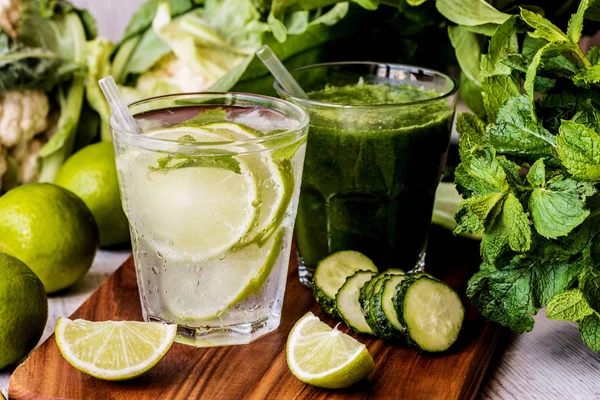 Grüner Smoothie und Entgiftungswasser mit Limette, Minze und Eis auf Holzgrund. Detox-Diät. Nahaufnahme — Stockfoto