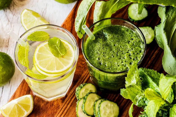 Green smoothie and detox water with lime, mint and ice on wooden background. detox diet. Close-up — Stock Photo, Image
