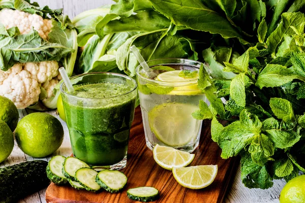 Zelené smoothie a detoxikační voda s limetkou, máta a ledu na dřevěné pozadí. detoxikační dieta. — Stock fotografie