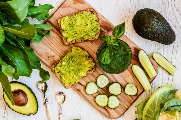 Üstten Görünüm. Yeşil smoothie ve avokado ile iki sandviç. sağlıklı vegan gıda