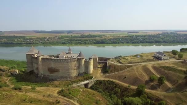 Vista aérea del castillo medieval de Khotyn en la colina verde sobre el río . — Vídeo de stock