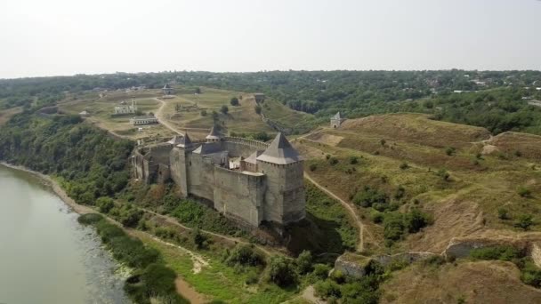 Luchtfoto van de middeleeuwse kasteel Khotyn op de groene heuvel boven de rivier. — Stockvideo