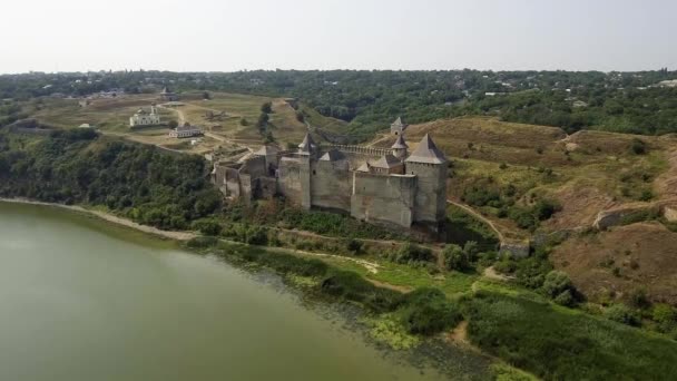 Пташиного польоту середньовічний замок Хотин на зеленому пагорбі над річкою. — стокове відео