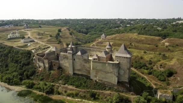 Vista aérea del castillo medieval de Khotyn en la colina verde sobre el río . — Vídeos de Stock