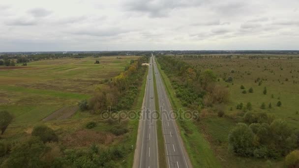 Vista aérea de la carretera que pasa a través de campos de cultivo . — Vídeos de Stock