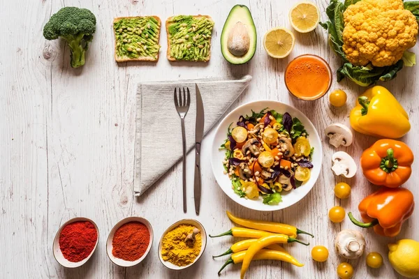 Comida saudável. salada de legumes, sanduíches de abacate vegan, suco fresco de cenoura e diferentes vegetais orgânicos coloridos e especiarias — Fotografia de Stock