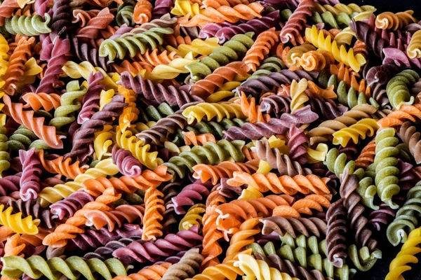 Kleurrijke fusilli pasta. Multicolor spiraal macaroni. Closeup. — Stockfoto