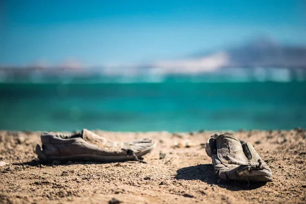 Пара старих туфель на піщаному пляжі. Старі туфлі на піску . — стокове фото