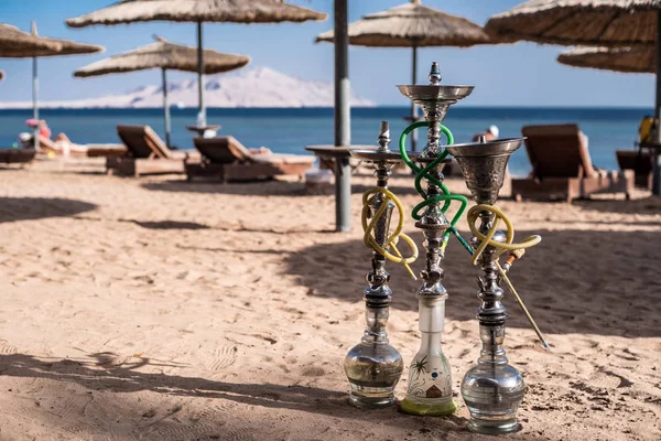 Tre lyxiga shisha vattenpiporna på sandiga stranden av Röda havet i Sharm El Sheikh, Egypten. — Stockfoto
