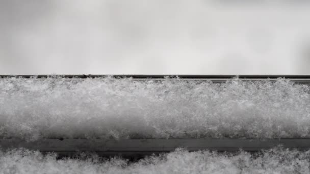 La nieve cae sobre el alféizar de la ventana. Primer plano — Vídeo de stock
