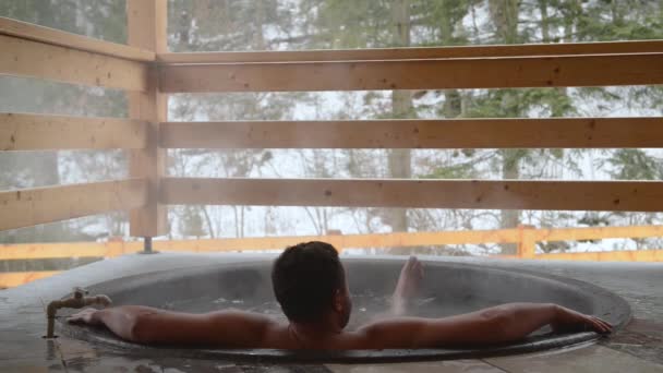 Un hombre se está bañando en la tina de hierro fundido con agua mineral . — Vídeos de Stock