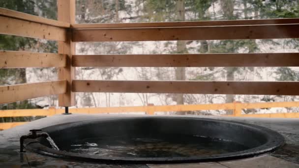 Den gusseisernen Bottich mit Mineralwasser und den Wasserhahn mit kaltem Wasser aufdrehen. — Stockvideo