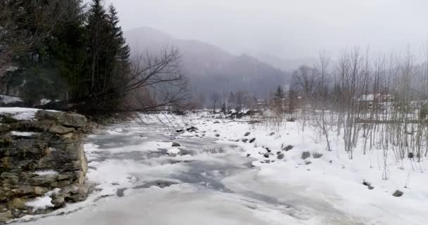 El hielo se derrite - el río fluye. Vista de un río de montaña en los Cárpatos en invierno . — Vídeo de stock