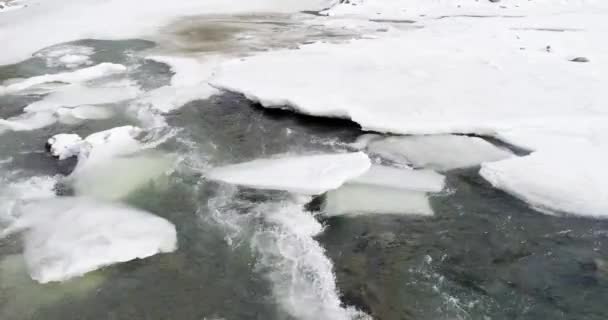 El hielo se derrite - el río fluye. Vista de un río de montaña en los Cárpatos en invierno . — Vídeos de Stock