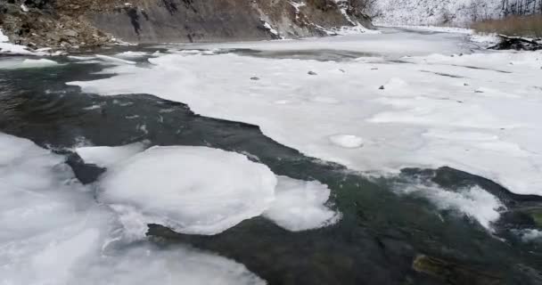 Пташиного польоту og лід тане - річка протікає. Вид на гірській річці, в Карпатах у зимовий період. — стокове відео