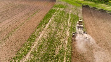 Bir alanda havadan görünümü bir traktörün. Leylek pulluk uçuyor.