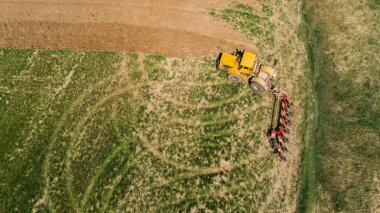 Bir tarladaki traktörün hava görüntüsü.