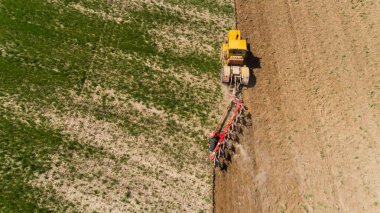 Bir tarladaki traktörün hava görüntüsü.