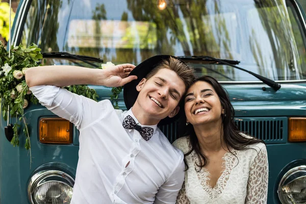 Cheerful happy young couple smiling near retro-minibus. Close-up.