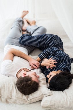 Neşeli mutlu genç çift bir yatak odasında sarılma. Portre.