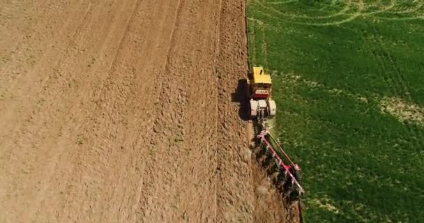 一辆拖拉机在田野上的空中镜头 拖拉机在春季犁耕犁 拖拉机犁地里 制造大量灰尘 — 图库视频影像