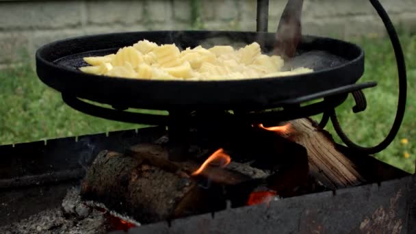 Izgarada ızgara patates ve dökme demir tava. Açık ateşte patates kızartma tavası.. — Stok video
