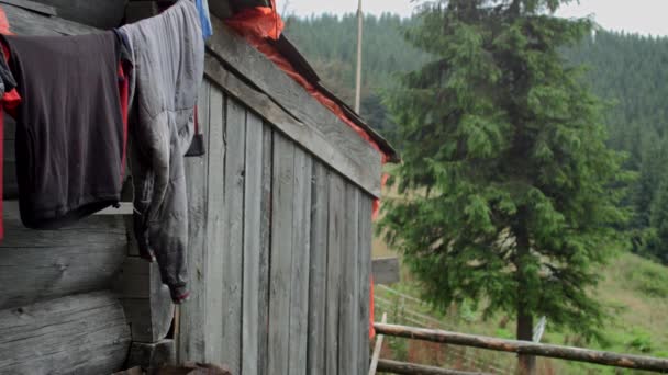 Casa forestal en las montañas. Ropa colgada de una cuerda cerca de la casa . — Vídeos de Stock