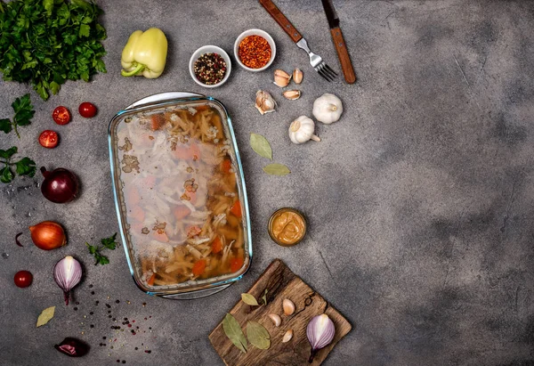 Homemade jelly with meat. Aspic poultry and beef, traditional Russian and Ukrainian dish on a gray background with mustard. Copy space