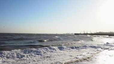 Kışın liman manzarası var. Kışın denizde fırtına olur. Martılar kışın kıyı boyunca rüzgara karşı uçar..