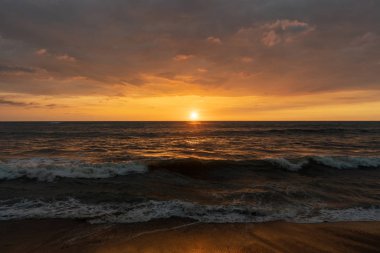 Okyanusta günbatımının panoramik görüntüsü. Gökyüzü, bulutlar, sahil ve sudan başka bir şey yok. Güzel sakin sahne
