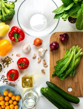 Tahtada Romaine marulu ve masada farklı sebze ve baharatlar. Pişirilmiş salata için malzemeler. Sağlıklı diyet vegan gıda konsepti. Üst görünüm.