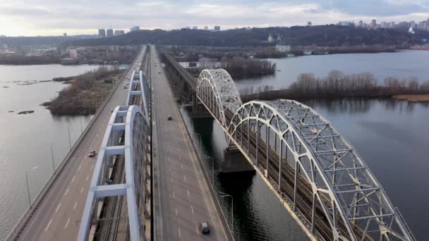 Widok z góry anteny samochodowe i kolejowe Darnytskyi mostu przez rzekę Dniepr z góry, panoramę miasta Kijów — Wideo stockowe