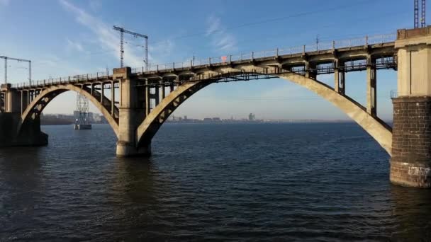 Aerial view under the Old Arch Railway Bridge in Dnipro City. Moving camera forward subject. — 비디오