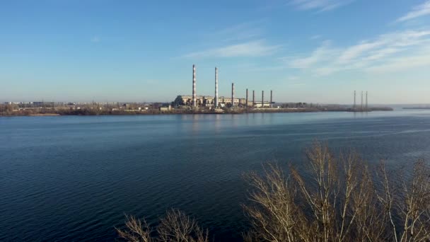 Повітряний вид промислового заводу з трубами для куріння в місті. Промислова зона. Сучасні технології очищення. Дивиться з-за дерев.. — стокове відео