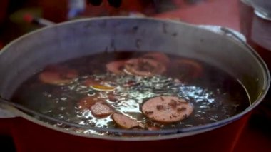 Punch ve bir kazan bir Noel Pazar üzerinde mulled şarap için malzemeler. Malzemeler narenciye ve baharat içkide, üzüm ve aplesine üzerinde kazan asmak. Kış sıcak içecek pişirme işlemi
