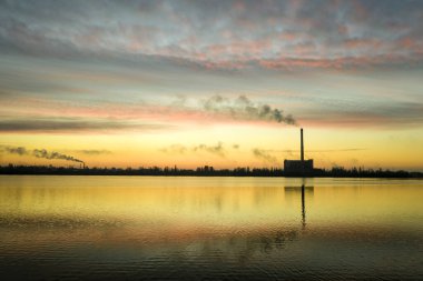 Güneş doğarken çöp yakma tesisi bacası. Çevre kirliliği.