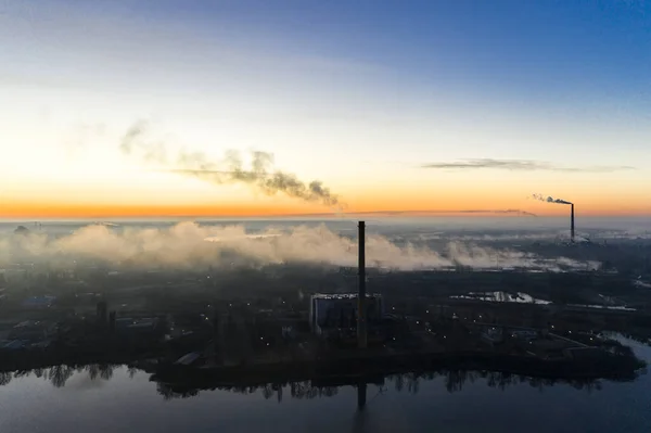 Centrais eléctricas fumegantes ao nascer do sol perto do lago. Poluição ambiental . — Fotografia de Stock