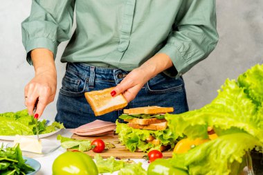 Kız kızarmış ekmeğe tereyağı sürer. Sandviç yapıyorum..