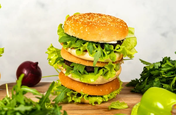 Lahodné hamburgery připravené v jasné kuchyni na dřevěném stole. Detailní záběr. — Stock fotografie