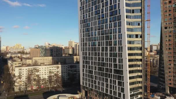 Ένας ημιτελής ουρανοξύστης στο κέντρο της πόλης. Η κάμερα κινείται από κάτω προς τα πάνω κατά μήκος ενός ουρανοξύστη. — Αρχείο Βίντεο